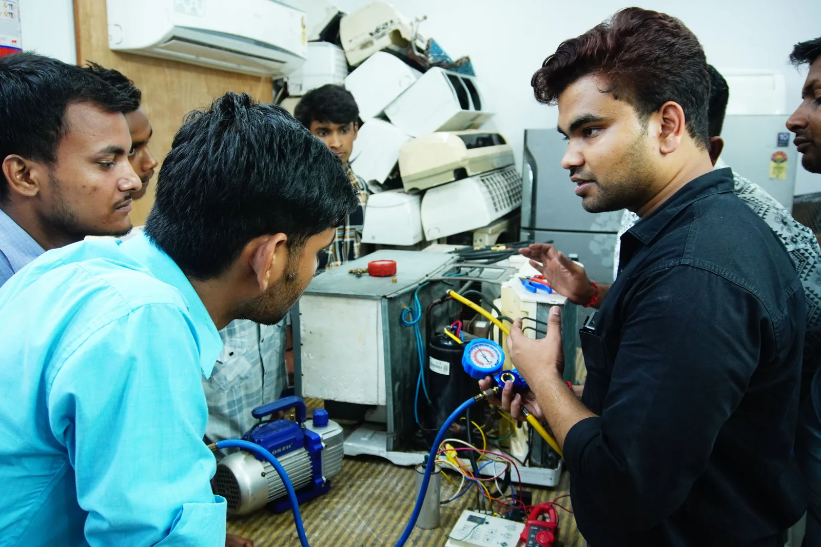 Participants learning air-conditioner repair techniques in a practical workshop